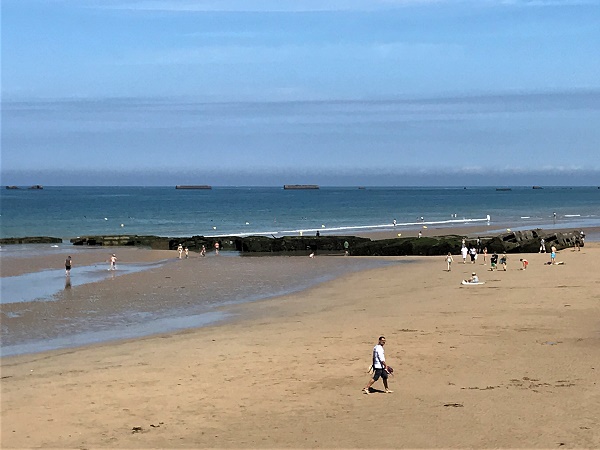 Gold beach, sulla costa della Normandia, con in lontananza i Mulberry, testimonianza dello sbarco durante la Seconda Guerra Mondiale.