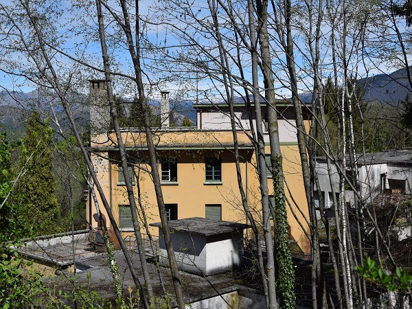 Sciesopoli si contempla solo dal cancello d’ingresso, la vegetazione cresce incolta e i grandi alberi la nascondono.