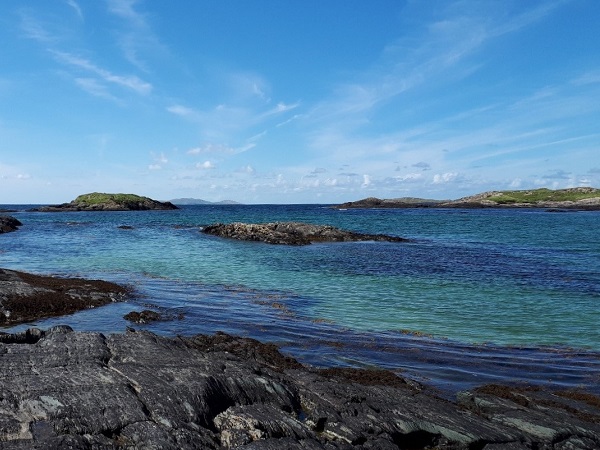 Nel Connemara, l’incantevole Glassilaun Beach con rocce nere che si diramano nell’oceano blu.