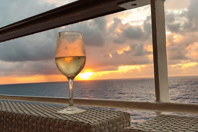 Le coccole tipiche della crociera: un calice di vino vista tramonto sul mare.