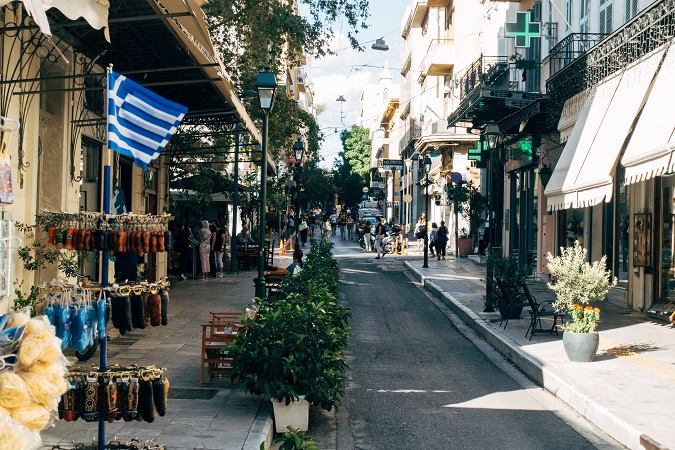 Un vicolo di Atene, con la bandiera della Grecia e un piccolo negozio di souvenir
