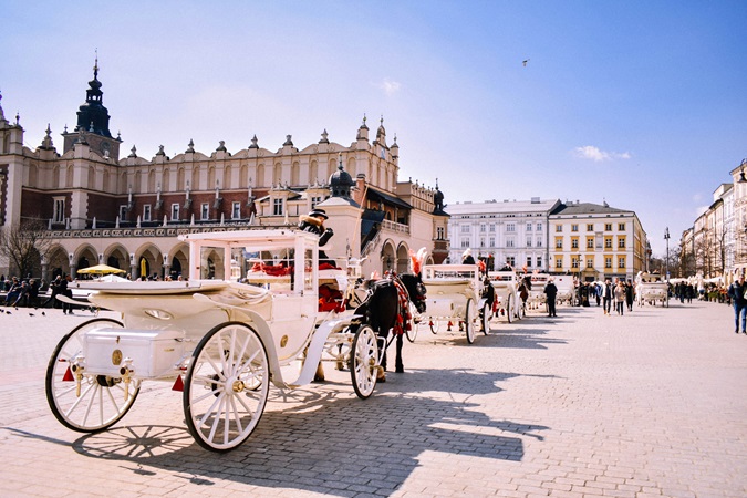 Vista di Rynek Główny con le carrozze di cavalli.